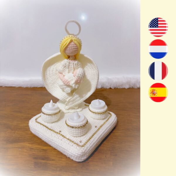 crochet guardian angel holding crochet baby on platform with LED candles in candle holders