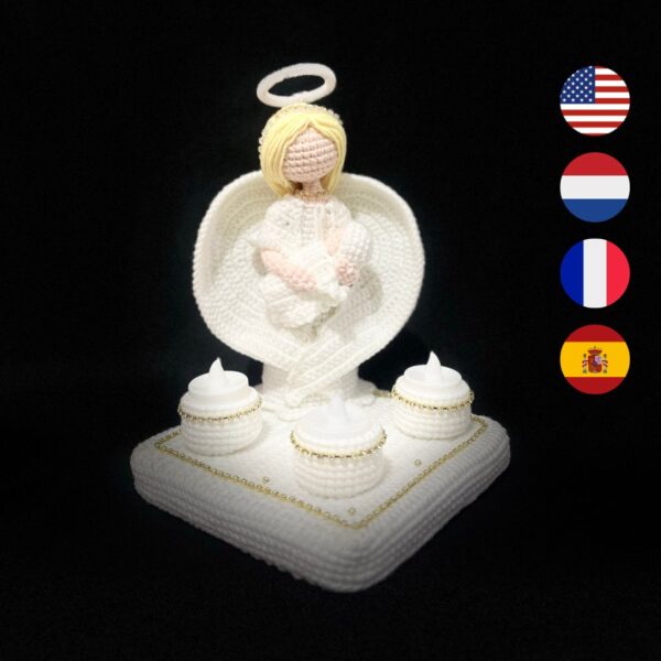 crochet guardian angel holding crochet baby on platform with LED candles in candle holders