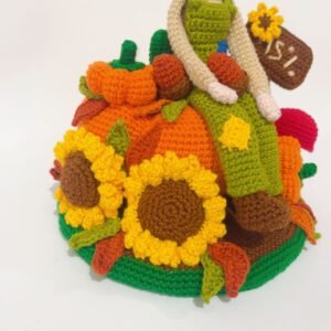 crochet scarecrow with crochet pumpkins, sunflowers, sign, leaves and a mushroom