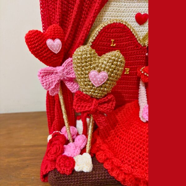 crochet lady in red dress in crochet Valentine setting with crochet hearts, roses, gift boxes and curtains