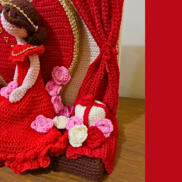 crochet lady in red dress in crochet Valentine setting with crochet hearts, roses, gift boxes and curtains