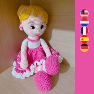 crochet doll wearing a pink dress and hearing aids