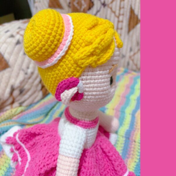 crochet doll wearing a pink dress and hearing aids