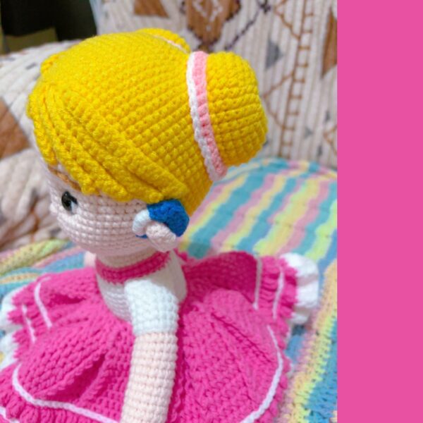 crochet doll wearing a pink dress and hearing aids