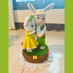 crochet Easter bunny boy and girl with butterflies, standing on a basket with grass in it