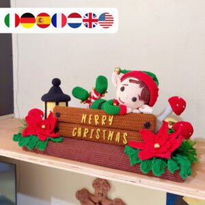 crochet elf on crochet wood, surrounded by poinsettias, holly leaves, mushrooms and a lantern